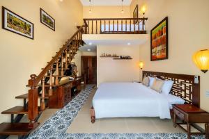 a bedroom with a white bed and a staircase at Hoi An May Village in Hoi An