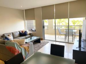 a living room with a couch and a table at 208 Santai - Spacious Family Apartment by uHoliday in Casuarina