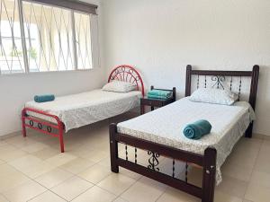 1 dormitorio con 2 camas y ventana en Agradable casa vacacional cerca al centro de Anapoima en Anapoima