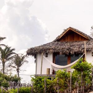 Casa con techo de paja y hamaca en la parte delantera en Tatadise, en Tatajuba