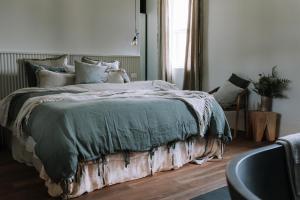 比奇沃斯The Benev - Wellness Accommodation and Spa Beechworth的卧室里有一张大床，上面铺着绿色毯子