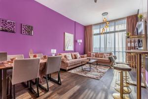 a living room with purple walls and a table and chairs at Live in style. Luxury destination - OIA - Motor City in Dubai