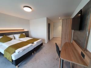 1 dormitorio con cama, mesa y escritorio en hb-Gästehaus 