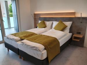 um quarto com uma cama grande e almofadas amarelas em hb-Gästehaus 