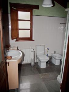 a bathroom with a sink and a toilet and a tub at Casa Rural La Cabaña del Valleyu in Sotres