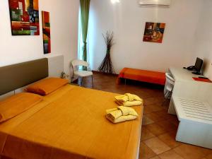 um quarto com uma cama com toalhas amarelas em Room in Guest room - Spend little and enjoy Sicily em Calatabiano