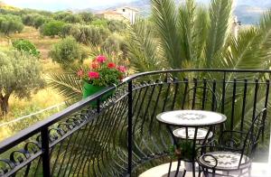 uma varanda com uma mesa e cadeiras e um vaso de flores em Room in Guest room - Spend little and enjoy Sicily em Calatabiano
