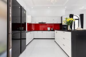 a red and white kitchen with a black refrigerator at Pallas Villa in Vung Tau