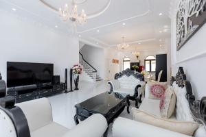 Il comprend un salon doté d'un mobilier blanc et d'une télévision à écran plat. dans l'établissement Pallas Villa, à Vung Tau