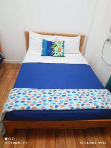 Una cama con una manta azul encima. en MJ Home en Manila