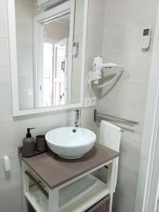 een badkamer met een witte wastafel en een spiegel bij Apartamentos Costa San Esteban in San Esteban de Pravia
