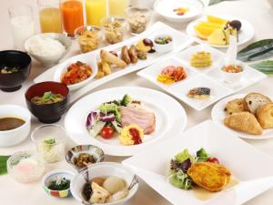 una mesa con platos de comida. en Himeji Castle Grandvrio Hotel, en Himeji