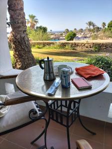 - une table sur un balcon avec une cafetière et un livre dans l'établissement Coral Bay Roby, à Charm el-Cheikh