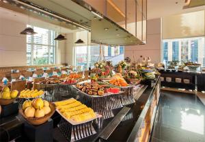 a buffet line with many trays of fruits and vegetables at Eastin Grand Hotel Sathorn in Bangkok
