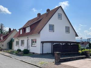 Biały dom z brązowym dachem w obiekcie Fewo Michalke w mieście Bodenfelde
