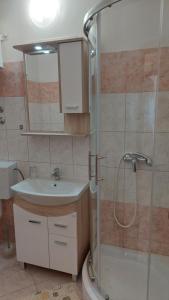 a bathroom with a sink and a shower at Apartments Donadic I, Caska in Novalja +37 photos