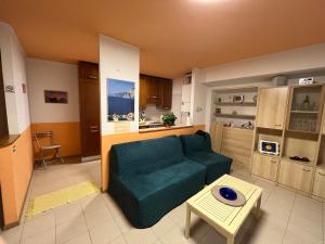 a living room with a green couch and a table at Appartamento Capri in Arco +54 photos