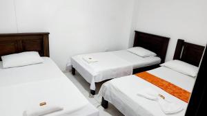Postel nebo postele na pokoji v ubytování Aparta Hotel El Cacique Upar