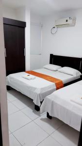 Postel nebo postele na pokoji v ubytování Aparta Hotel El Cacique Upar