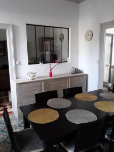 a dining room with a black table and chairs at Maison de ville proche beauval avec parking in Selles-sur-Cher