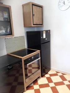 a kitchen with a counter and a black refrigerator at Maison de ville proche beauval avec parking in Selles-sur-Cher