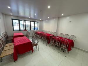 een kamer met tafels en stoelen met rode tafelkleden bij Khách sạn Sông Chanh 3 Cát Bà in Cat Ba