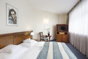 a hotel room with two beds and a television at Hollywood Media Hotel am Kurfürstendamm in Berlin