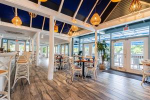 a restaurant with tables and chairs and windows at Park Shore Resort 3rd Floor Bldg H in Naples