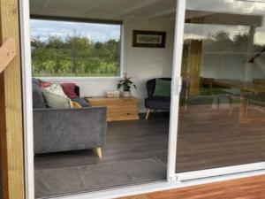 a living room with a couch and a sliding glass door at The Tiny Nest in Palmerston North