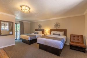 a hotel room with two beds and a chair at Cedars Resort in Sedona