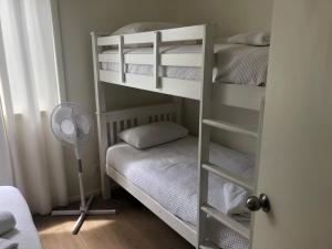 a room with two bunk beds and a fan at Haven House in Shoalhaven Heads