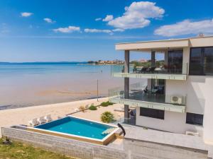 dom na plaży z basenem w obiekcie Jimmys Beach - direkt am Meer, tollem Blick und beheiztem Pool w mieście Privlaka