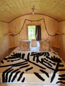 Cama con estampado de cebra en una habitación de madera en LES ROULOTTES DU PILAT, en Maclas