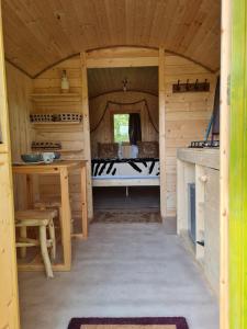 une vue intérieure sur une cabane en bois avec une table et un banc dans l'établissement LES ROULOTTES DU PILAT, à Maclas