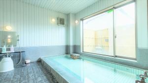 a bathroom with a swimming pool with a large window at Hotel Isesaki East in Isesaki