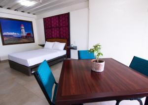 um quarto com uma mesa de jantar e uma cama e um quarto com um farol em Leuchtturm Resort em Boljoon