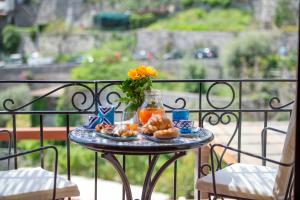 einen Tisch mit einem Teller Essen auf dem Balkon in der Unterkunft Casa Mamà in Positano