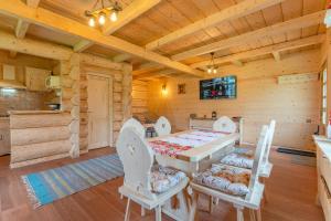 ein Esszimmer mit einem Tisch und Stühlen in einer Blockhütte in der Unterkunft Cabane de Poveste in Bran