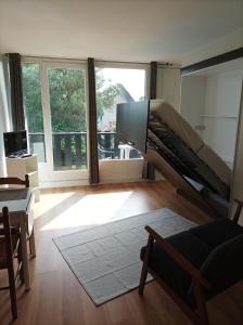 een woonkamer met een tv en een bank bij Studio tout confort au bord du lac d'Estey in Dax