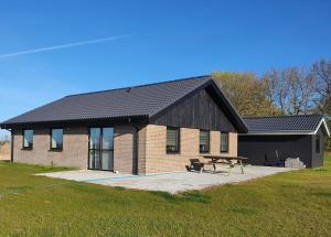 a brick house with a picnic table in front of it at Fælleshuset Kirkebakken in Otterup