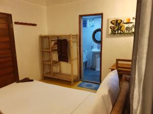 a bedroom with a bed and a bathroom with a mirror at Jambiani Guest Lodge PEMBA in Jambiani