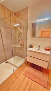uma casa de banho com um lavatório e um chuveiro em La douce Rive em Esneux