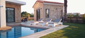 Villa Alexandros في كيساموس: مسبح مع كرسيين جلوس بجانب بيت