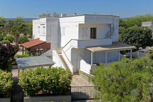 una casa blanca con árboles delante en Villetta Terme di Torre Canne, en Torre Canne
