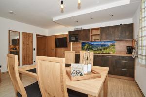 拉姆紹的住宿－Ferienwohnungen Bergfex，厨房以及带木桌和椅子的用餐室。