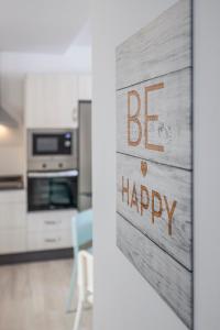 a kitchen with a be happy sign on the door at Family HOME SUITS Encantos de Sevilla in Seville