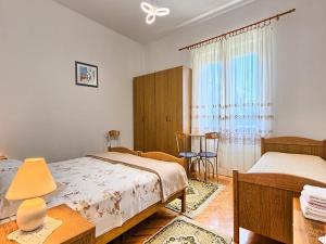 1 dormitorio con 2 camas, mesa y ventana en Apartment Lucija, en Kaštela