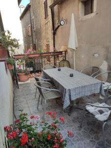 - une table et des chaises sur une terrasse fleurie dans l'établissement Rooms Svalina Adults Only, à Grožnjan