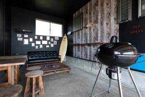 ein Zimmer mit einem Grill, einer Bank und einem Tisch in der Unterkunft Marine House KAKISAKI in Shimoda