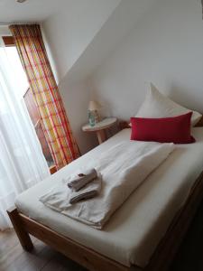 a bedroom with a large bed with a red pillow at Helgas Landhotel in Oberreute